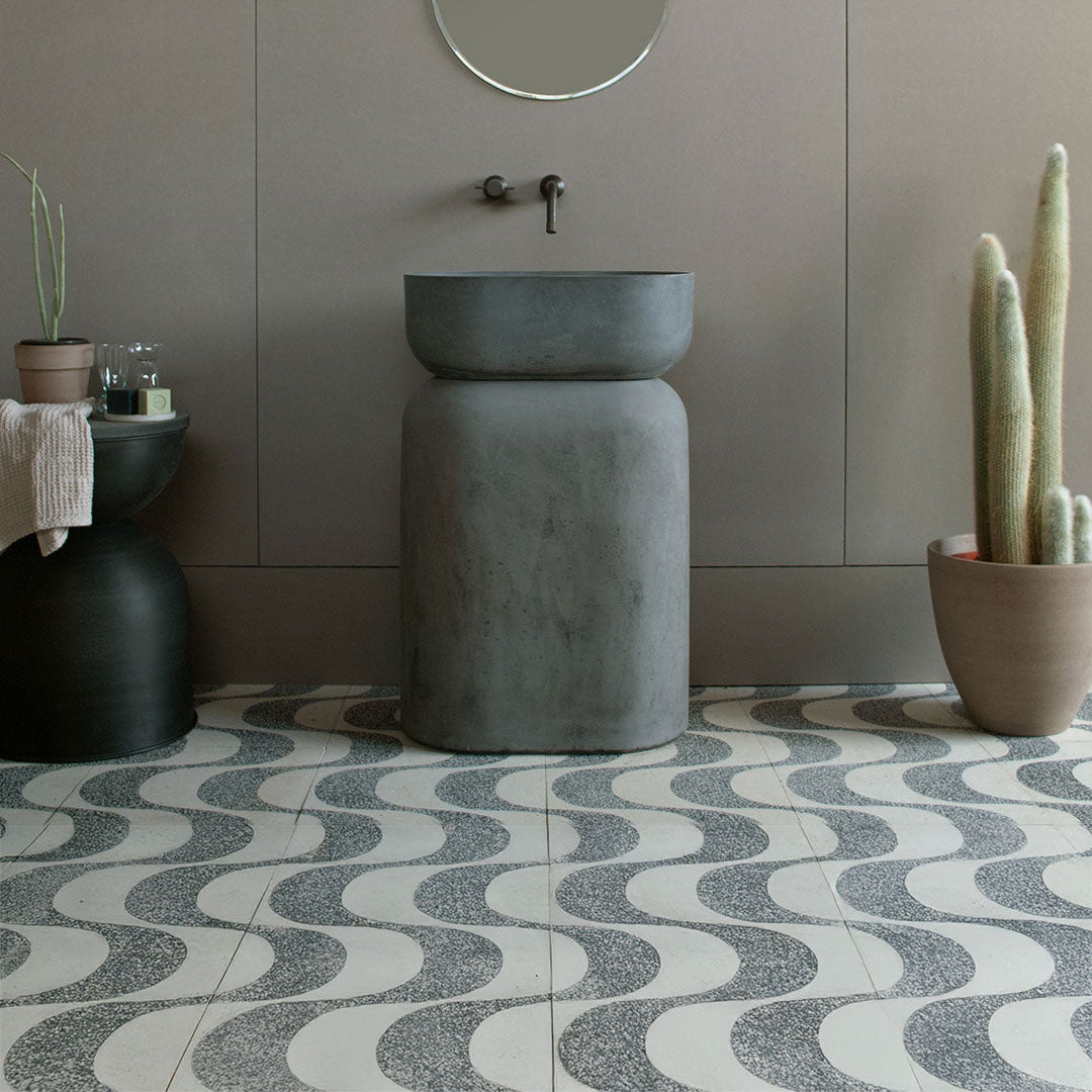 Cement tile featuring a terrazzo wave pattern in black and white tones, curved geometric design, matte finish, ideal for modern, retro, or contemporary interior flooring and wall décor applications.