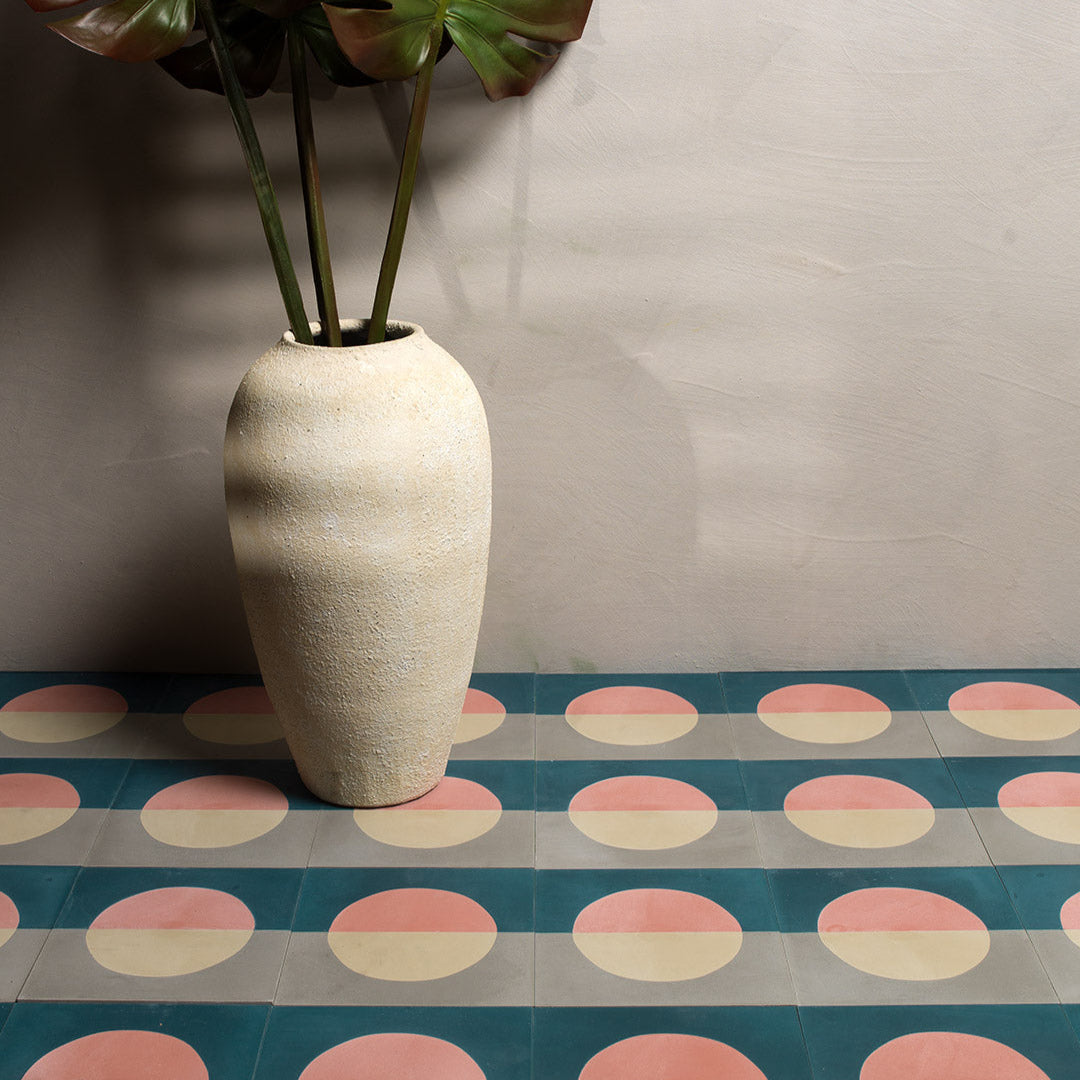 Cement tile featuring a minimalist geometric design with a pink and cream circle over teal blue and gray halves, matte finish, ideal for modern, abstract, or Scandinavian interiors.