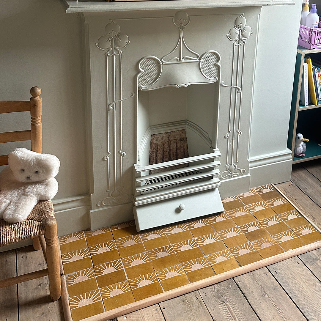 Decorative fireplace with a patterned rug on a wooden floor