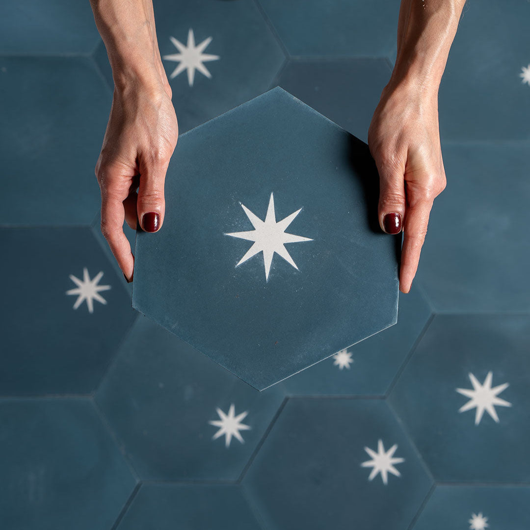 Cement tile featuring a hexagonal shape in deep teal blue with white starburst motifs, matte finish, ideal for modern, celestial, or Mediterranean interior flooring and wall décor applications.
