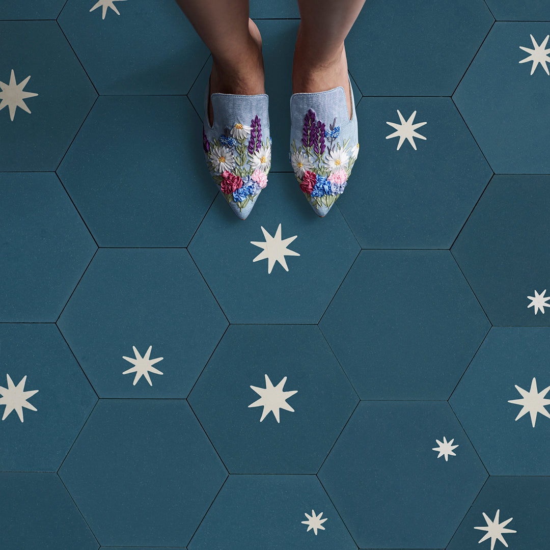 Cement tile featuring a hexagonal shape in deep teal blue with white starburst motifs, matte finish, ideal for modern, celestial, or Mediterranean interior flooring and wall décor applications.