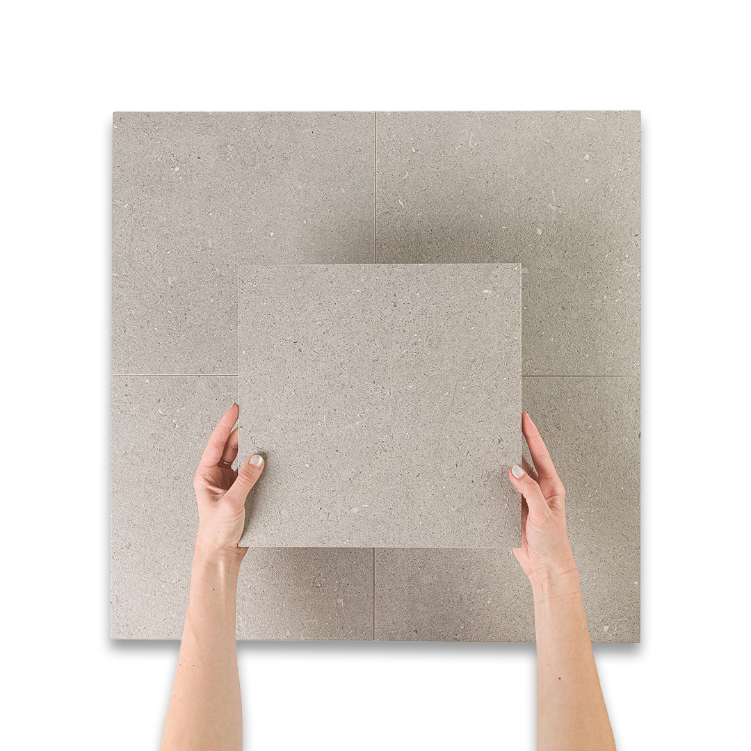 Two hands holding a square piece of gray fabric against a white background