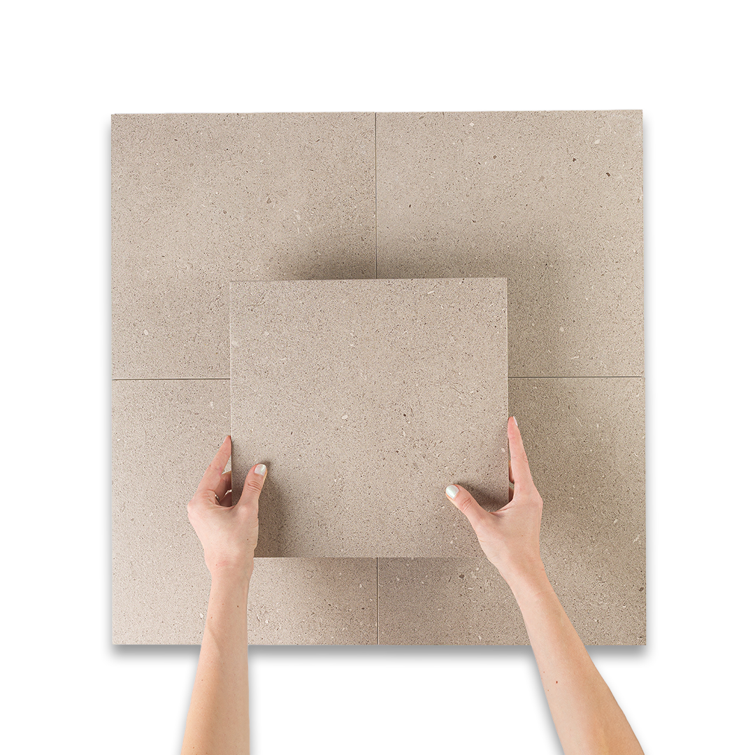 Beige tiles being held by hands on a white background