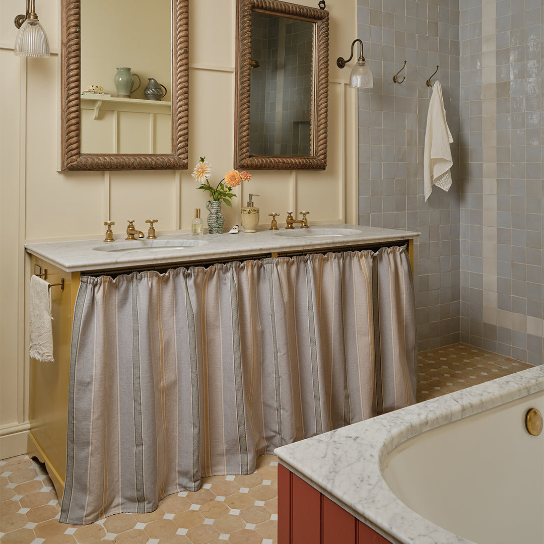 Bathroom with vanity, mirrors, and a bathtub with a curtain.
