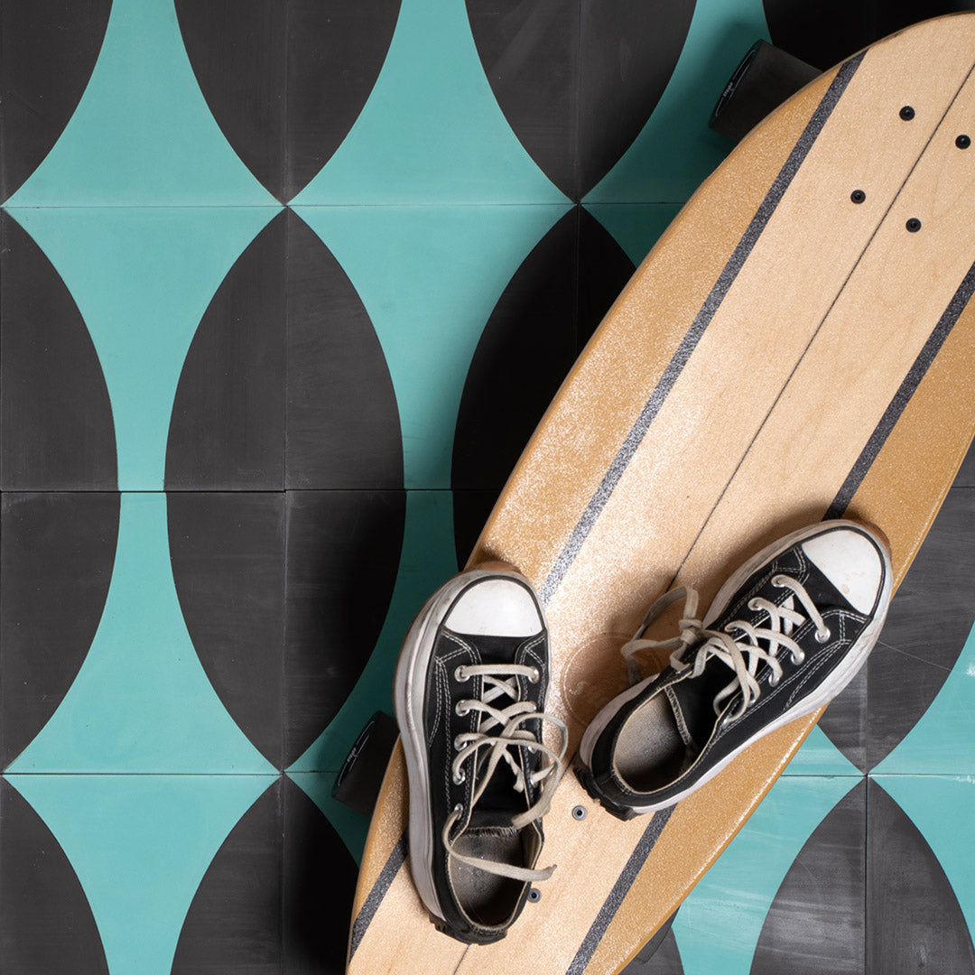 Cement tile featuring a curved teal blue geometric pattern on a matte black background, ideal for modern, contemporary, or art deco interior flooring and wall décor applications.