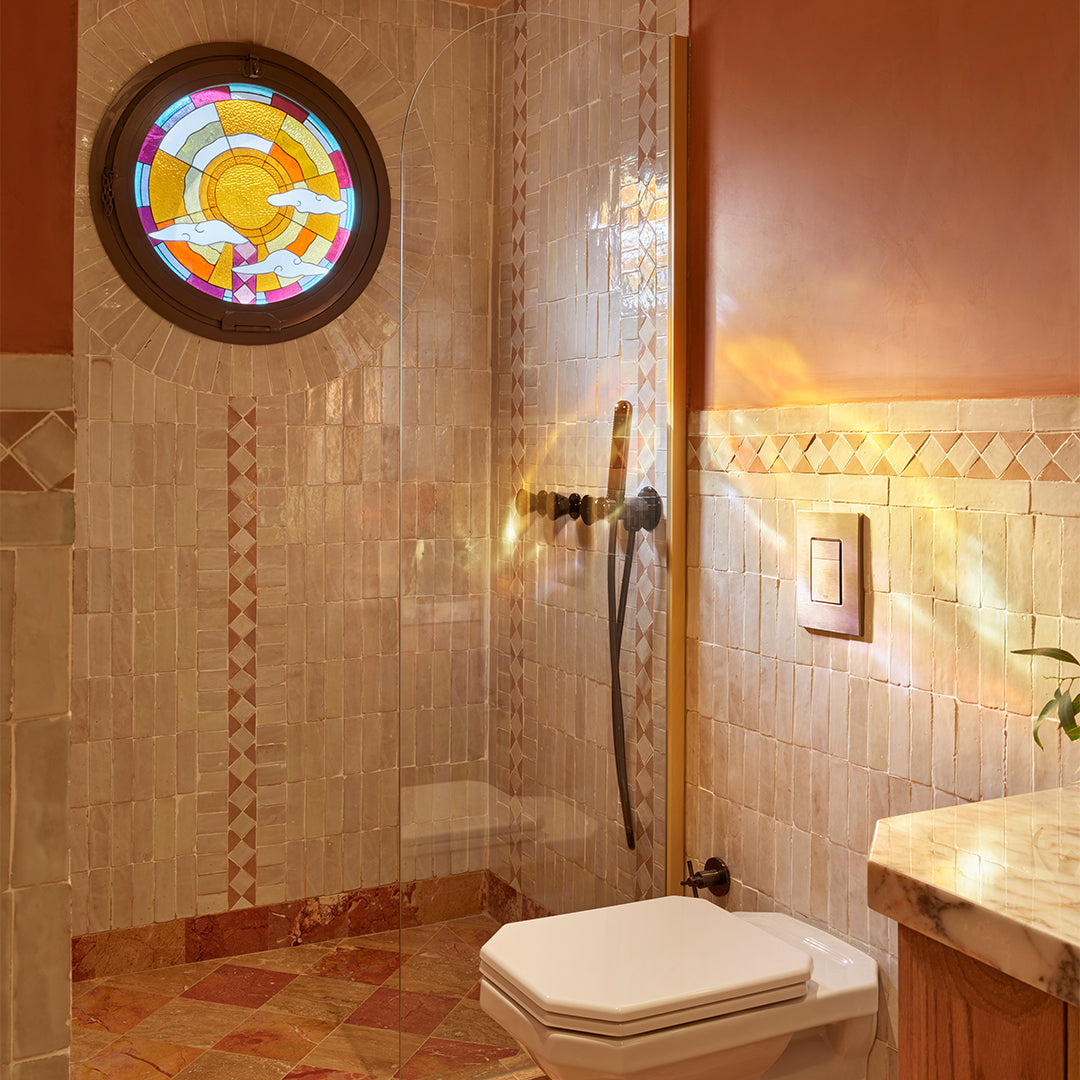 Bathroom with tiled walls, a stained glass window, and a toilet.
